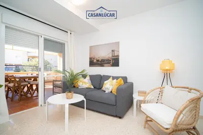 a living room with a couch and a chair at Vivienda Magallanes in Sanlúcar de Barrameda