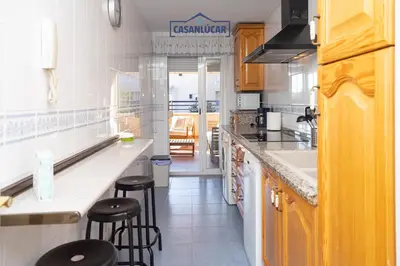 a kitchen with a counter and stools in it at Vivienda Magallanes in Sanlúcar de Barrameda