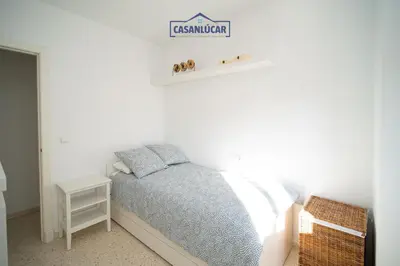 a bedroom with a bed and a sign on the wall at Vivienda Magallanes in Sanlúcar de Barrameda