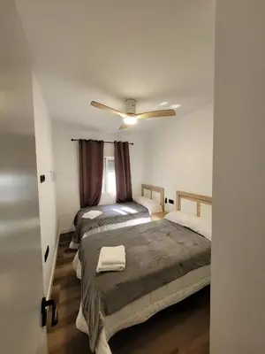 a bedroom with two beds and a ceiling fan at Caímachado in Cádiz