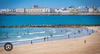 a group of people in the water at a beach at Caímachado in Cádiz