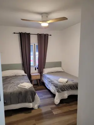 a bedroom with two beds and a ceiling fan at Caímachado in Cádiz