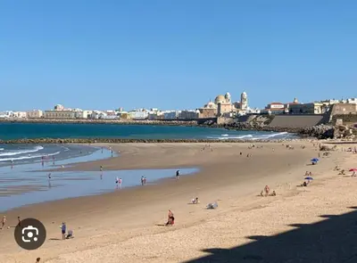 a group of people on a beach near the ocean at Caímachado in Cádiz