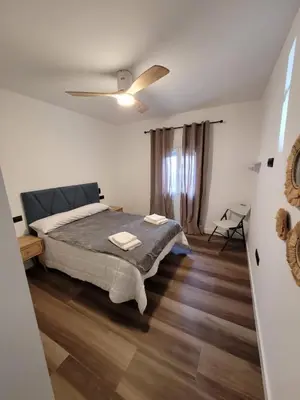 a bedroom with a bed and a ceiling fan at Caímachado in Cádiz