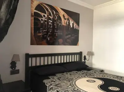 a bedroom with a bed with a picture on the wall at Apartamento Bulerias de Jerez in Jerez de la Frontera