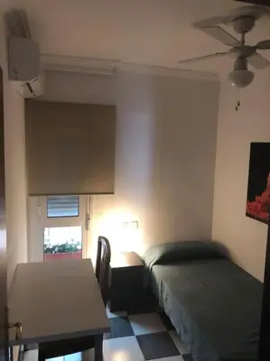 a bedroom with a bed and a desk and a table at Apartamento Bulerias de Jerez in Jerez de la Frontera