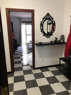 a hallway with a mirror and a checkered floor at Apartamento Bulerias de Jerez in Jerez de la Frontera
