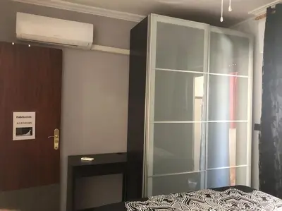 a bedroom with a glass cabinet next to a bed at Apartamento Bulerias de Jerez in Jerez de la Frontera