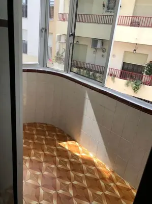 a room with a tiled floor and two windows at Apartamento Bulerias de Jerez in Jerez de la Frontera