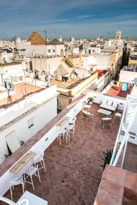 a balcony with tables and chairs on top of a building at Torre Solana 41 in Cádiz
