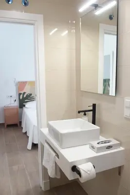 a bathroom with a white sink and a mirror at Torre Solana 41 in Cádiz