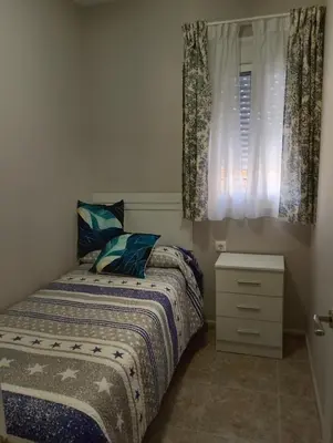 a bedroom with a bed and a window with curtains at LOS MELLIS in Sanlúcar de Barrameda