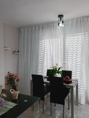 a dining room with a table and chairs in front of a window at LOS MELLIS in Sanlúcar de Barrameda
