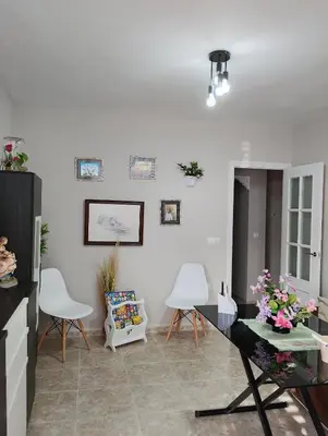 a living room with a table and white chairs at LOS MELLIS in Sanlúcar de Barrameda