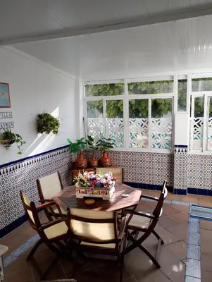 a dining room with a table and chairs and windows at LOS MELLIS in Sanlúcar de Barrameda