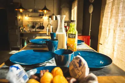 a table with blue plates of food and bottles of milk at Gatu Selecta 5 Diseño calidad wifi, aire acc junto recinto ferial, Preferente mayores de 21 años y familias in Jerez de la Frontera