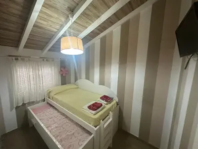 a small bedroom with a bed and a lamp at Duplex centro/playa in Sanlúcar de Barrameda