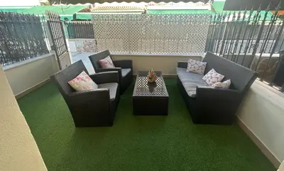 a balcony with two chairs and a couch and a table at Duplex centro/playa in Sanlúcar de Barrameda