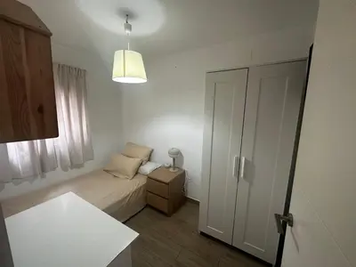a small bedroom with a bed and a window at Duplex centro/playa in Sanlúcar de Barrameda