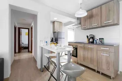a kitchen with a counter and a table in it at La casa de la playa in El Puerto de Santa María