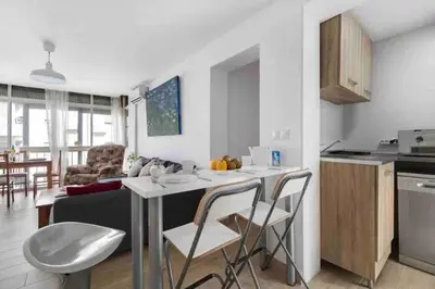 a kitchen and living room with a table and chairs at La casa de la playa in El Puerto de Santa María