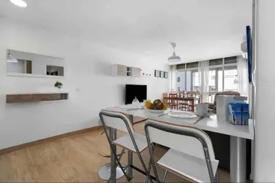 a kitchen and dining room with a table and chairs at La casa de la playa in El Puerto de Santa María