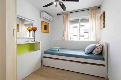 a bedroom with a bed with a window at La casa de la playa in El Puerto de Santa María