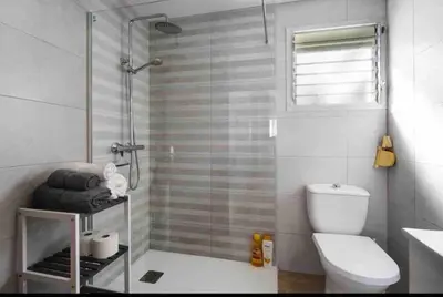a bathroom with a shower and a toilet and a sink at La casa de la playa in El Puerto de Santa María