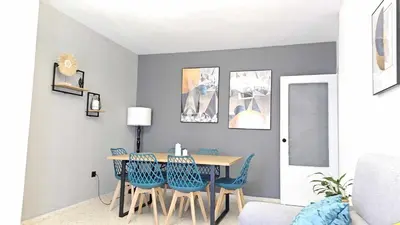 a dining room with a table and blue chairs at Karma loft en la playa by Sanlúcar Housing in Sanlúcar de Barrameda