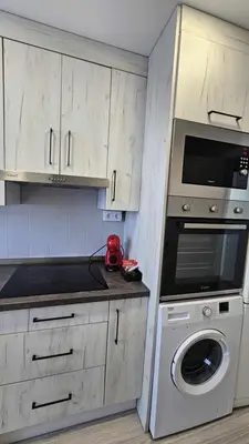 a kitchen with a washing machine and a microwave at Karma loft en la playa by Sanlúcar Housing in Sanlúcar de Barrameda