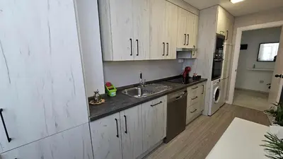 a kitchen with white cabinets and a sink at Karma loft en la playa by Sanlúcar Housing in Sanlúcar de Barrameda