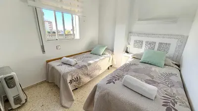 a bedroom with two beds and a window at Karma loft en la playa by Sanlúcar Housing in Sanlúcar de Barrameda