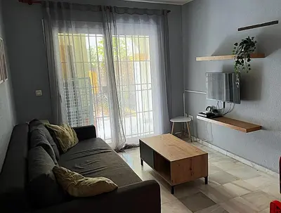 a living room with a couch and a coffee table at Apartamento Red -primera linea de playa in El Puerto de Santa María