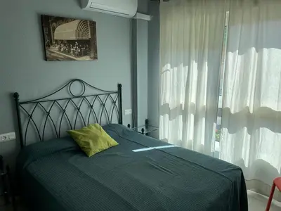 a bedroom with a green bed with a yellow pillow at Apartamento Red -primera linea de playa in El Puerto de Santa María