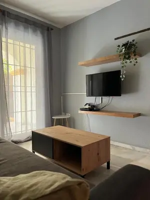 a bedroom with a tv and a wooden coffee table at Apartamento Red -primera linea de playa in El Puerto de Santa María