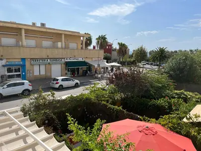 a view of a street with a building and a red umbrella at Apartamento Red -primera linea de playa in El Puerto de Santa María
