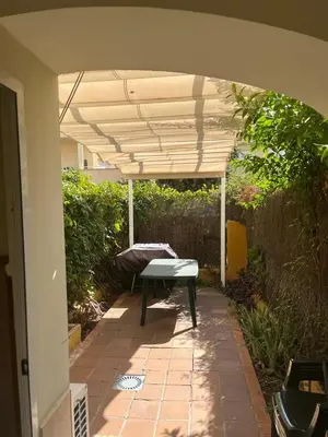 a patio with a bench under an umbrella at Apartamento Red -primera linea de playa in El Puerto de Santa María