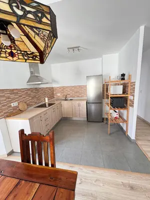 a kitchen with a stainless steel refrigerator and a table at Cabildo 2 in Sanlúcar de Barrameda