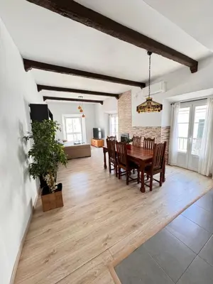 a dining room and living room with a table and chairs at Cabildo 2 in Sanlúcar de Barrameda
