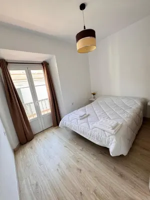 a bedroom with a large bed and a large window at Cabildo 2 in Sanlúcar de Barrameda