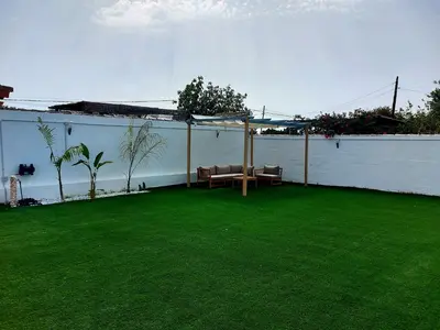 a patio with a table and chairs on a lawn at Chalet Vacacional Chiclana in Chiclana de la Frontera