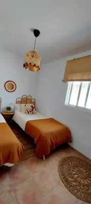 a bedroom with two beds and a chandelier at Chalet Vacacional Chiclana in Chiclana de la Frontera