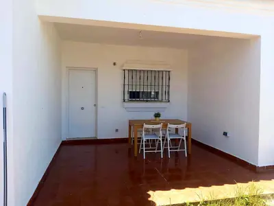 a dining area with a table and chairs in a room at Chalet Vacacional Chiclana in Chiclana de la Frontera