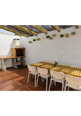 a table and chairs in a room with a piano at Chalet Vacacional Chiclana in Chiclana de la Frontera