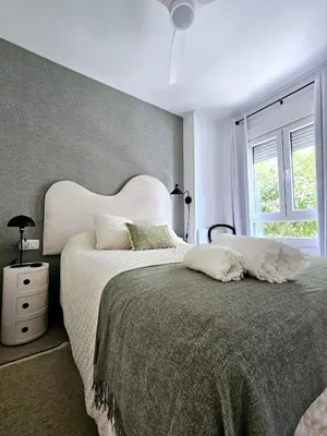 a bedroom with a large bed and a window at Apartamento Vetalegua Jerez in Jerez de la Frontera