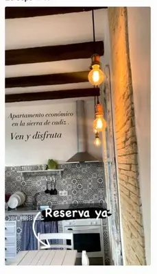a kitchen with a table and a sign on the wall at Casa Puerta sierra de Cádiz in Arcos de la Frontera