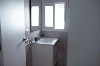 a bathroom with a white sink and two windows at APARTAMENTO EL EMBRUJO in Jerez de la Frontera