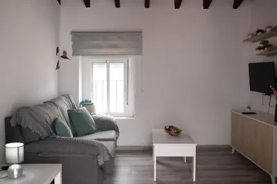 a living room with a couch and a table at APARTAMENTO EL EMBRUJO in Jerez de la Frontera
