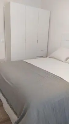 a large white bed in a white bedroom at Casa Ángeles in Cádiz