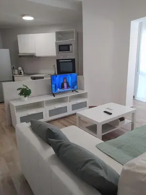 a living room with a couch and a tv at Casa Ángeles in Cádiz